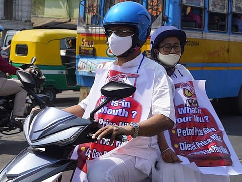 West Bengal Chief Minister Mamata Banerjee rides pillion on an electric scooter to work on Thursday in protest against the rising fuel prices in India. Firhad Hakim, the Kolkata Mayor and a senior minister, is in the driver's seat.