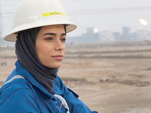 Ayat Rawthan, a petrochemical engineer, poses for a photo near an oil field outside Basra.