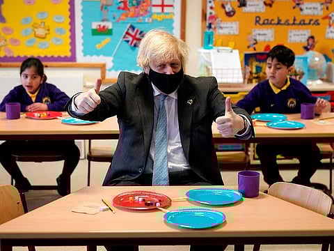 Britain's Prime Minister Boris Johnson, wearing a face covering and making the 'thumbs-up' sign, joins Year 2 pupils in a maths lesson, during his visit to St Mary's C.E. Primary School in Stoke-on-Trent, central England on March 1, 2021, to see how their preparations are going ahead of students returning on March 8, after England's third lockdown.