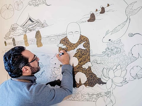 Ansar working on a 'Monk and Koi' painting