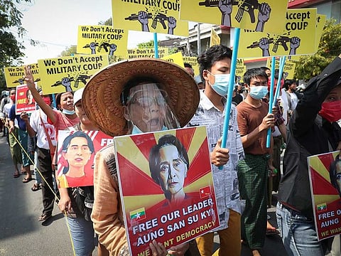 Protesters shout slogans and display images of deposed Myanmar leader Aung San Suu Kyi during an anti-coup protest march in Mandalay, Myanmar, Monday, March 1, 2021.