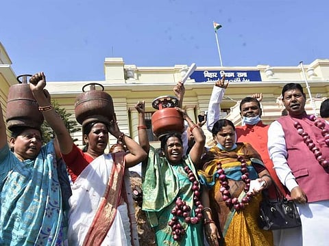 Opposition lawmakers protest with LPG cylinders on their heads in the Bihar assembly to highlight soaring fuel prices on Tuesday, March 2, 2021.