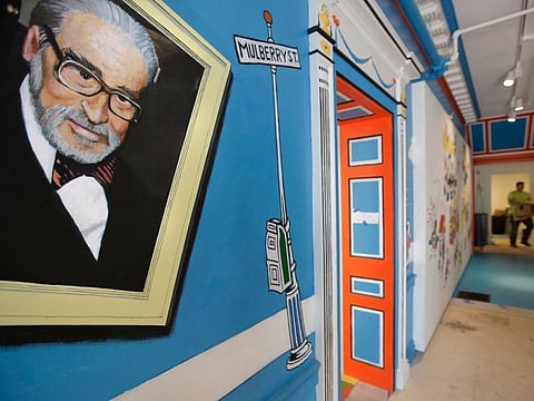 In this May 4, 2017, file photo, a mural that features Theodor Seuss Geisel, left, also know by his pen name Dr. Seuss, covers part of a wall near an entrance at The Amazing World of Dr. Seuss Museum, in Springfield, Mass.