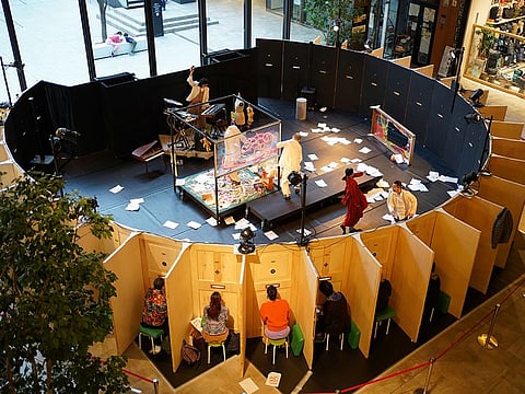 Audience members watch the Moonlight Mobile Theatre's dance performance through peepholes at a shopping mall in Nagoya, Japan.