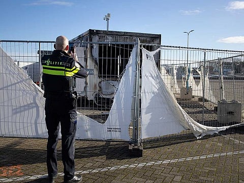 In this Jan. 24, 2021, file photo, a police officer takes pictures of a burned-out coronavirus testing facility in the fishing village of Urk in the Netherlands after it was set on fire the night before by rioting youths protesting on the first night of a nationwide curfew.