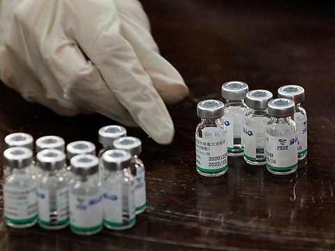 A health worker counts used vials of Sinopharm's coronavirus disease vaccine.