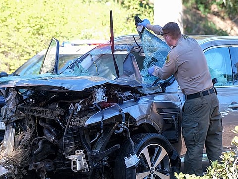 February 23, 2021 file photo: A law enforcement officer looks over a damaged vehicle following a rollover accident involving Tiger Woods in the Rancho Palos Verdes suburb of Los Angeles.