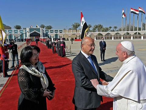 A handout picture released by the Vatican media office on March 8, 2021, shows Iraq's President Barham Saleh and his wife Sarbagh bidding farewell to Pope Francis during the farewell ceremony at the conclusion of the pontiff's visit to Iraq, at the capital's Baghdad International Airport.