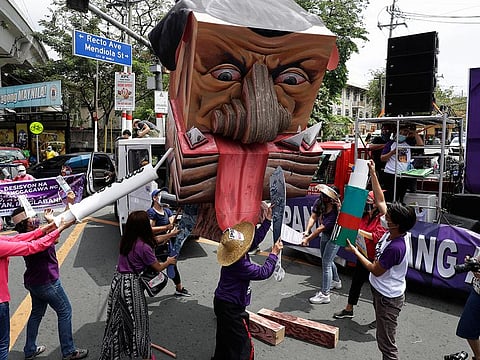 Women activists destroy an effigy of Philippine President Rodrigo Duterte during a rally near the Malacanang presidential palace to mark International Women's Day.
