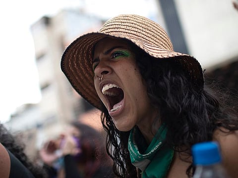 A woman from the feminist group "Tinta Violeta" shouts slogans demanding justice for women who have been victims of violence during a protest marking International Women's Day in Caracas, Venezuela, Monday, March 8, 2021