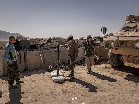 Afghan Army commandos fire a mortar from an outpost near the front line with the Taliban in Panjwai, Afghanistan, March 7, 2021. An unofficial cease-fire brokered there by local officials, farmers and Taliban forces is an example of how communities, driven by despair, have engineered their own ways to stop the fighting.