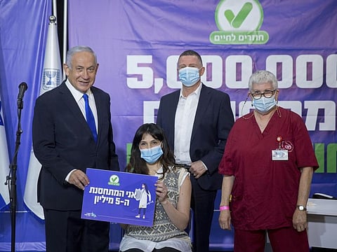 Israeli Prime Minister Benjamin Netanyahu and his Health Minister Yuli Edelstein meet Israeli citizen (no name given) no. 5,000,000 who got the Pfizer-BioNTech COVID-19 vaccine in Tel Aviv March 8, 2021.