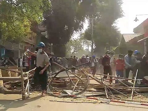 People flee to safety during a protest in Mandalay, Myanmar March 10, 2021 in this still image obtained by Reuters from a social media video.