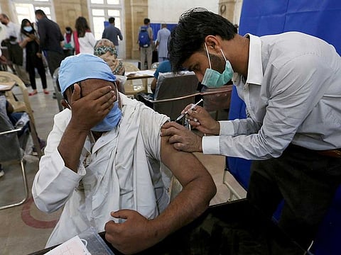 A man receives vaccine from a health worker in Karachi in a file photo. According to the NCOC data, 951,140 vaccines were administered across Pakistan in last 24 hours while the total number of vaccine administered by the same date was 65,505,999 (65.505 million).