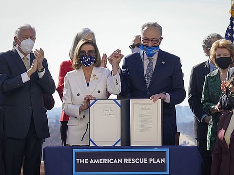 Surrounded by Democratic House and Senate Committee Chairs, Speaker of the House Nancy Pelosi (D-CA) and Senate Majority Leader Chuck Schumer (D-NY) sign the $1.9 trillion COVID-19 relief bill during a bill enrollment ceremony on the West Front of the U.S. Capitol on March 10, 2021 in Washington, DC.