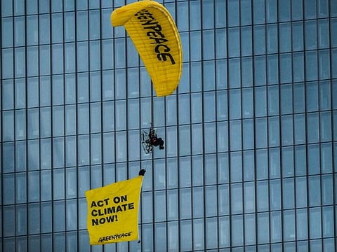 An activist on a paraglider protests with a flying banner, in Frankfurt, Germany.