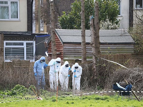 Forensic officers conduct a search behind a house in Deal, south east England, Friday March 12, 2021.
