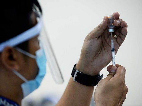 A health worker prepares a syringe with the Sinovac COVID-19 vaccine.