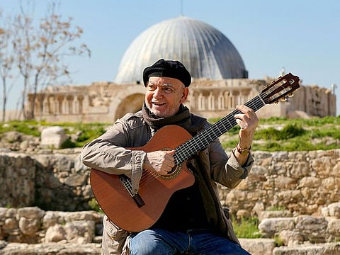 Iraqi musician Ilham Al Madfai, is pictured with his guitar in the ruins of the Amman Citadel in the Jordanian capital.