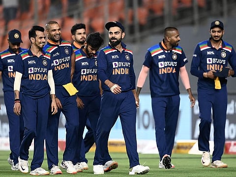 India's captain Virat Kohli (C) along with his teammates walks back to the pavilion at the end of the first Twenty20 match vs England at the Narendra Modi Stadium in Motera on March 12, 2021.