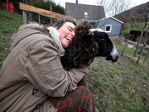 Lexa Voss, personality development coach, cuddles sheep Karlotta at her little farm, where she holds sheep cuddling seminars during COVID-19 lockdown in Hattingen, near Wuppertal, Germany.