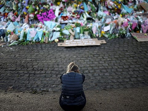 A mourner sits in front of a memorial site at the Clapham Common Bandstand, following the kidnap and murder of Sarah Everard, in London, Britain.