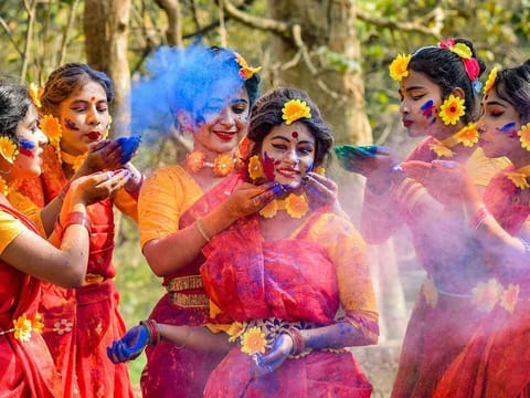 Women smear dry colours on each other during Holi celebrations in Nadia district, Tuesday, March 16, 2021.