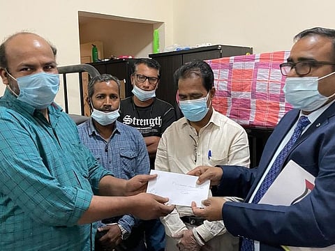 Harjeet Singh (right) hands over a free ticket to one of the stranded passengers sheltered by community group Orma.