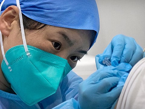 A medical worker gives a coronavirus vaccine shot to a patient at a vaccination facility in Beijing.