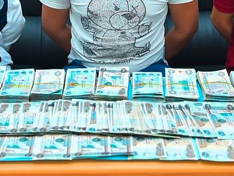 The arrested gang members with part of the stolen cash.