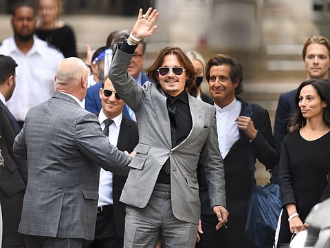 In this file photo taken on July 28, 2020 US actor Johnny Depp (C) gestures as he leaves the High Court after the final day of his libel trial against News Group Newspapers (NGN), in London.