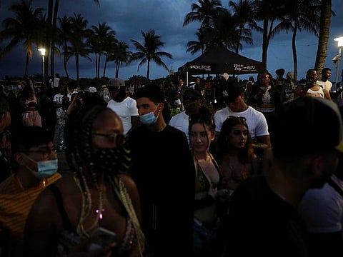 People walk along Ocean Drive during spring break festivities in Miami Beach, Florida.