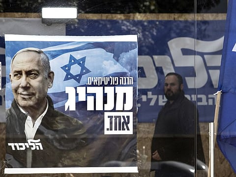 A man walks past a Likud party campaign poster for Prime Minister Benjamin Netanyahu in the city of Sderot, Israel, Friday, March 19, 2021. Israel will be holding its fourth election in two years on March 23.