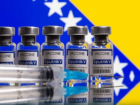 Vials labelled "Sputnik V coronavirus disease (COVID-19) vaccine" and a syringe are seen in front of a displayed Bosnian flag in this illustration picture taken March 17, 2021.
