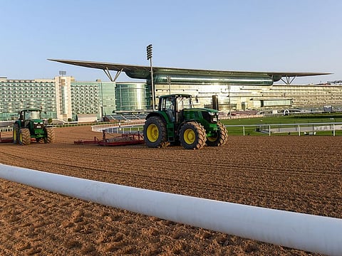 Workers furrow the dirt track at Meydan ahead of Saturday's 25th running of Dubai World Cup.