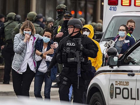 Healthcare workers walk out of a King Sooper's Grocery store after a gunman opened fire on March 22, 2021 in Boulder, Colorado.