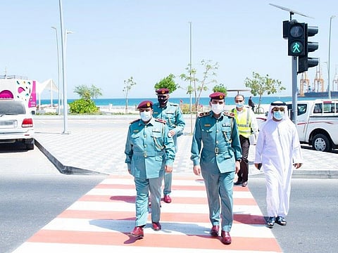 Officials use the pedestrian crossing on Khor Fakkan's Al Corniche Road.