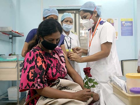 A healthcare worker holding a rose receives an AstraZeneca's COVISHIELD vaccine, during the coronavirus disease (COVID-19) vaccination campaign, at a medical centre in Mumbai, India, January 16, 2021.