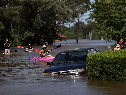 People using kayaks and paddle boards navigate a residential neighbourhood inundated with floodwaters as severe flooding affects the suburb of McGraths Hill in Sydney, Australia, March 24, 2021.