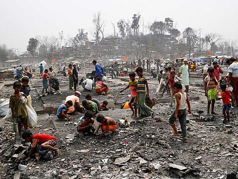 Rohingya refugees search for valuable materials, such as gold, in the ashes after a massive fire broke out two days ago and destroyed thousands of shelters in Cox's Bazar, Bangladesh, March 24, 2021.