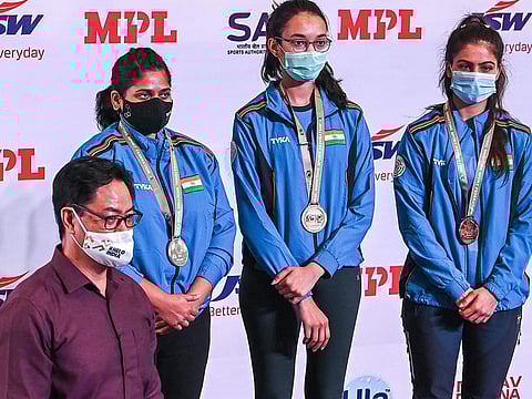 Indian trio of Chinki Yadav (centre), Rahi Sarnobat (left) and Manu Bhaker at the podium after receiving their medals from Kiren Rijuju, Union Minister of Sports, in New Delhi on Wednesday.