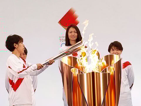 The torch is lit by a member of Japan's women's national football team "Nadeshiko Japan" during the Tokyo 2020 Olympic Torch Relay Grand Start in Naraha, Fukushima prefecture, northeastern Japan, Thursday, March 25, 2021.