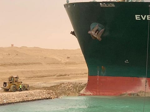 Workers try to move the Ever Given vessel on the Suez Canal.