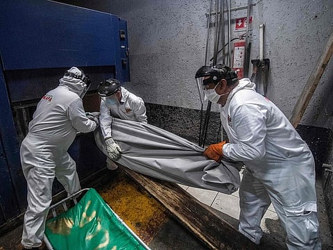 In this file photo taken on June 11, 2020, employees of the Iztapalapa pantheon manoeuver to put a body bag with the remains of a victim of COVID-19 in an oven at the crematorium, in Mexico City, amid the novel coronavirus pandemic.