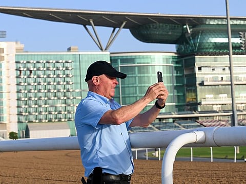 Michael Stidham, veteran Godolphin America trainer, keeps a watch as Mystic Guide works out at Meydan on Thursday.