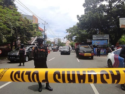 Armed police officers stand guard along a closed road following an explosion outside a Catholic church in Makassar, South Sulawesi province, Indonesia, March 28, 2021.