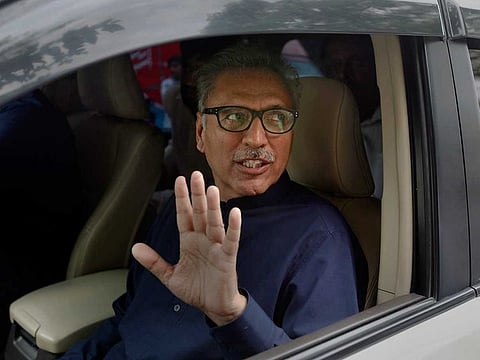 In this Aug. 27, 2018 file photo, Arif Alvi, then a lawmaker from Imran Khan's Tehreek-e-Insaf ruling party waves to media after filing his nomination papers in the presidential election, in Islamabad, Pakistan.