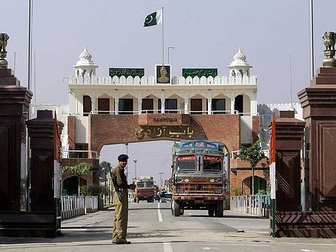 In this Feb. 26, 2009 file photo, an Indian border security force soldier stands guard as an Indian truck, exporting goods to Pakistan, returns back towards the Indian side of joint check post between India and Pakistan at Wagah, India.