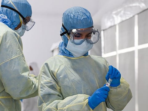 Paramedics collect swab samples at a coronavirus screening station.