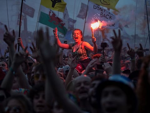 In this file photo taken on June 29, 2019, revellers watch as British singer Liam Gallagher performs on the Pyramid Stage at the Glastonbury Festival of Music and Performing Arts on Worthy Farm near the village of Pilton in Somerset, South West England.